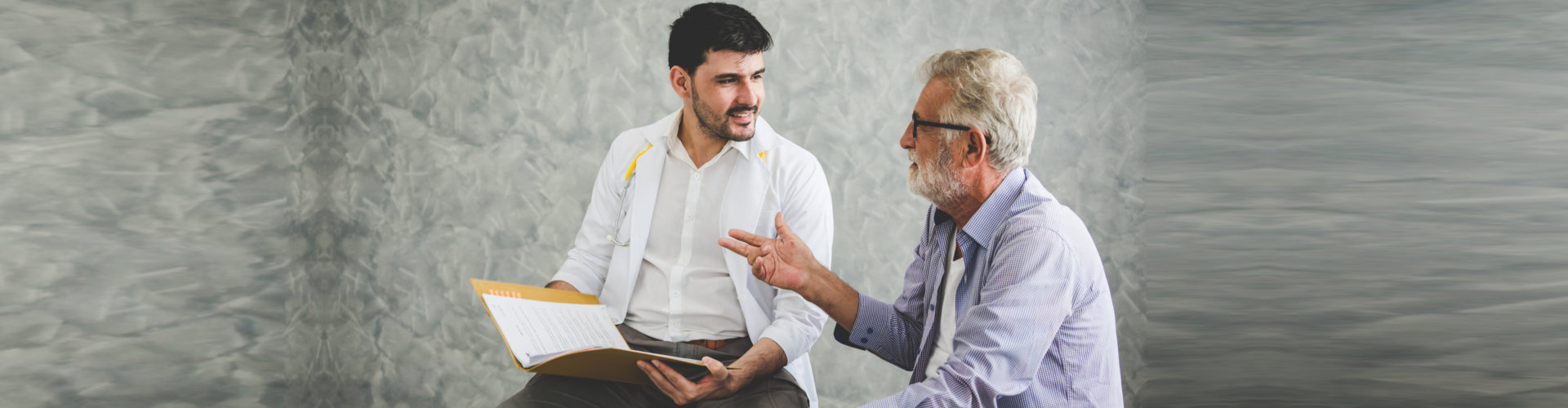 senior man wearing eyeglasses talking with his speech therapist
